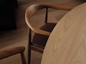 A round wooden table with matching chairs, showcasing a sleek, curved design.
