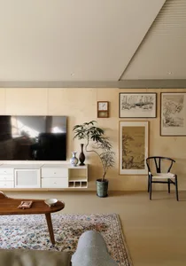 A minimalist living room with a wooden floor, wood furniture, and decorative accents.