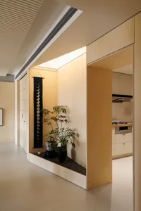 Interior of a minimalist residential kitchen with wooden cabinets and a small garden area.