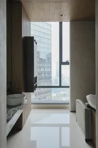 Modern bathroom featuring floor-to-ceiling windows with a view of the cityscape.