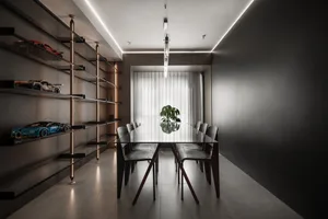 Modern dining room with metallic open shelving and a glass top table.