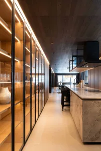 Modern kitchen featuring marble countertops and wooden cabinets.