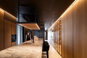 Modern kitchen with marble countertops and wooden cabinets in a residential setting.