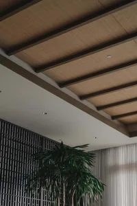 Indoor office space featuring a wooden ceiling with a modern design.