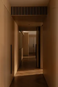 A minimalist corridor with timber walls and a wooden floor.