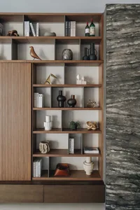 A modern wooden bookshelf adorned with various decorative items and books.