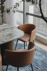 Modern dining room featuring a granite tabletop and brown leather chairs