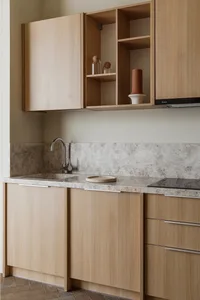 A modern kitchen featuring wooden cabinets, a sink, and a backsplash with a speckled pattern.