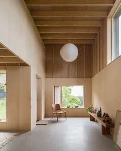 A modern living space featuring wooden paneling and a high ceiling.