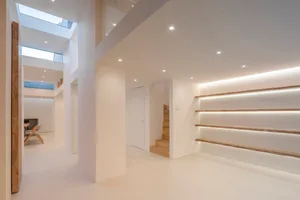 現代簡約室內空間，白色牆面搭配木質元素，白色木地板、木質層架與最小化設計
