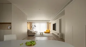 Modern minimalist living room with wood flooring, fabric sofa, and yellow accent chair.