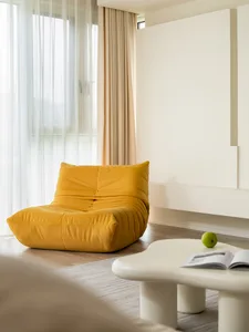 A modern living room with a bright yellow sofa, open curtains, and a white coffee table with a green apple and an open book.