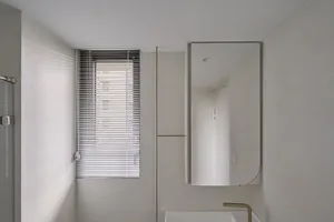 Minimalist bathroom interior featuring modern window blinds in a sleek design.