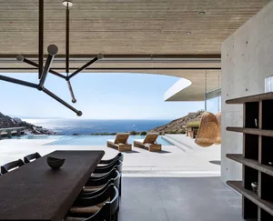 Concrete patio with lounge chairs, infinity pool, and scenic ocean view