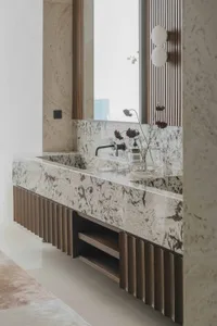 Modern bathroom featuring a granite countertop with a sleek, contemporary faucet and a vase of flowers.