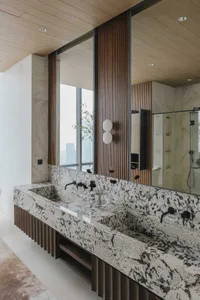 Modern bathroom interior featuring granite countertops and marble backsplash.