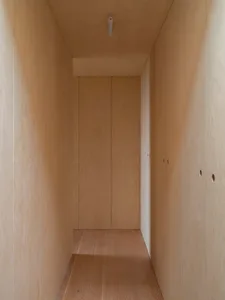 A modern closet with wooden panels and a wooden floor.