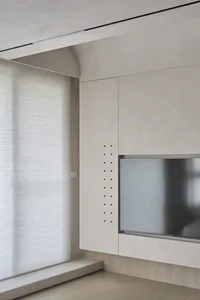 Modern grey concrete living room with minimalist decor and large windows.