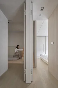 A modern interior space with wooden flooring and furniture.