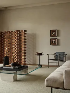 A modern living room featuring a wood laminate floor, minimalist furniture, and decorative elements such as a wooden screen a