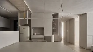 Modern minimalist interior with white walls, concrete columns, wooden floors, and white furniture.