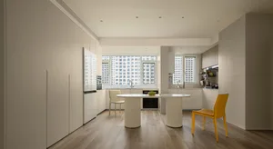 Modern kitchen with white paneling and wooden floor.