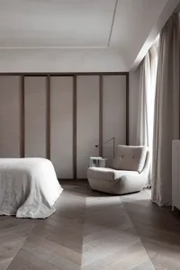 Minimalist bedroom featuring fabric furniture, wood flooring, and glass panels.