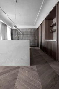 Modern apartment interior with open-plan kitchen, wooden flooring, and wooden shelving.