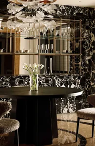 Modern dining room featuring marble walls, glass shelves, and a wooden dining table.