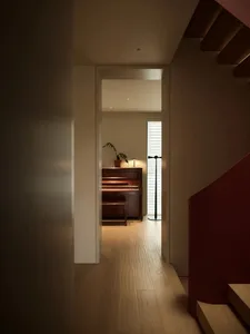 A wooden-floored music room with a piano and a plant.