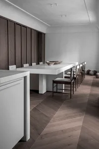 Modern minimalist kitchen with a white concrete table and chairs.