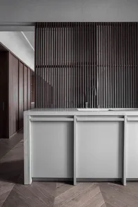 A modern minimalist kitchen with wood elements, featuring a sink and cabinets.