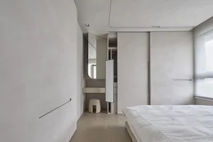 Contemporary minimalist bedroom featuring neutral-toned furniture and minimalist design elements.