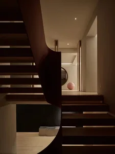 Modern architectural space featuring a curved wooden walkway and stairs.