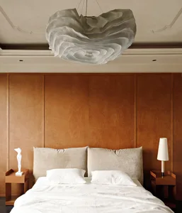 A minimalist bedroom with white bedding, gray headboard, and paneled wood walls