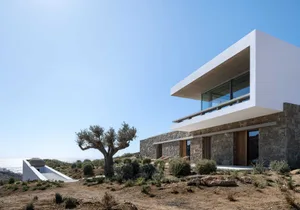 Modern house with concrete, stone, and brick exterior materials.