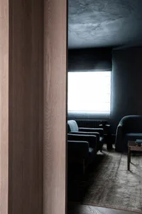 A minimalist interior space featuring wood and concrete finishes.