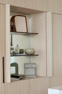 A modern interior design featuring a wooden shelving system with various decorative items.