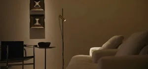 Modern living room setting with fabric sofa, metal floor lamp, and wood side table.