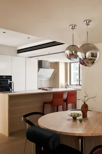 Modern residential kitchen with a combination of wood, marble, and metal materials.