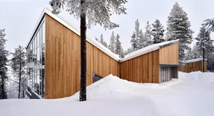Modern residential building with wooden exterior and snowy landscape