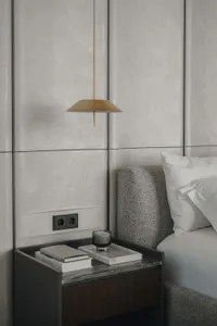 Modern bedroom showcasing metallic accent lamp and concrete paneling headboard