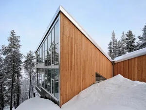 Modern building exterior with wooden features and snow-covered ground.