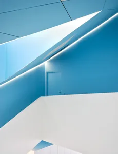 Blue and white geometric interior with concrete walls and minimalist design