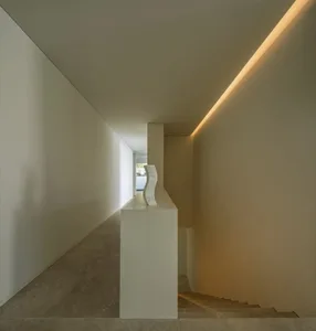 Modern minimalist interior featuring marble elements and warm lighting.