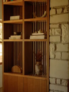 A modern wooden bookshelf with books and decorative items.