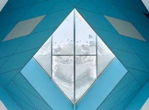 A modern interior design featuring a glass window with a blue geometric pattern.