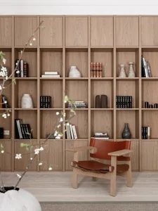 A modern living room featuring a natural wood bookshelf with decorative vases and books.