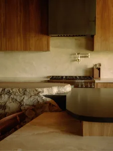 Modern kitchen with stone countertop and wooden cabinets.