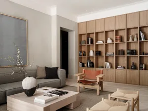 Modern living room with wood accents, leather chair, and bookshelves